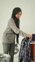 Asian woman in hijab drying her laundry at home photo