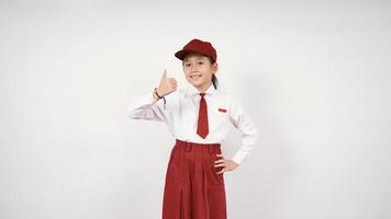 sonriente y bien niña de la escuela primaria asiática aislada sobre fondo blanco foto