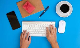 Blank notebook with pen is placed on an office desk table with computer tools and a range of materials. finance and banking background, flat lay, top view photo