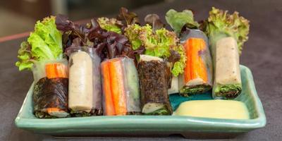 Healthy food concept. Salad roll made from fresh lettuce, seaweed, crab stick, and Vietnamese chicken wrap with rice vermicelli served with dipping sauce. photo