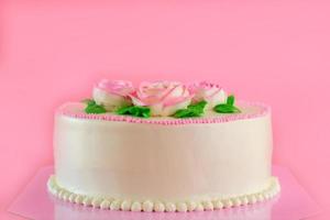 crema de mantequilla de rosas rosadas decorada con pastel de estanque de vainilla sobre fondo rosa con espacio para copiar servido en fiestas de cumpleaños y bodas. deliciosa panadería dulce para alguien que amas. foto