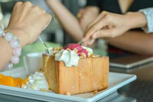 Eatting honey toast with red homemade ice cream and whipping cream topping in cafe and restaurant. photo