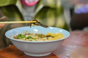 comida local tailandesa del norte de tailandia. comer fideos de arroz con salsa picante de cerdo con palillos. enfoque selectivo. foto