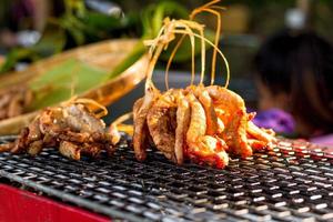 Grilled chicken with herb on roaster with thin bamboo sell at local market. Food concept. photo