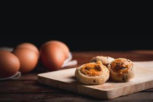 Cashew nut and black seasame cookies on wooden chopping board and table. Delicious snack for coffee time. photo