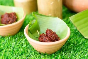 Thai northern chili paste on banana leaves and terracotta bowl. photo
