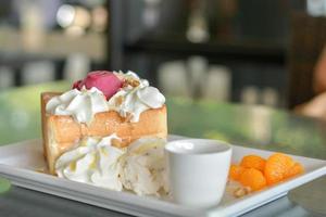 Honey toast with red homemade ice cream and whipping cream topping serve with orange in cafe and restaurant. photo
