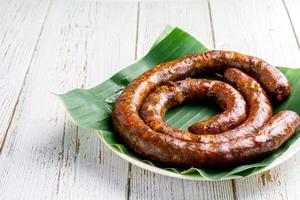 Thai northern herb sausage on white dish on table with copy space for your text. Thai food concept. photo