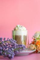 Ice coffee with a layer of milk and whipping cream with color sugar topping on pink background. Beverage and drink at the party concept. photo