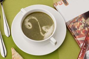 soup and a book on a green tablecloth photo