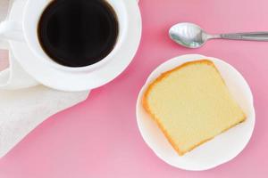 trozo de pastel de mantequilla en un plato blanco servido con una taza de café negro. tiempos para relajarse concepto. foto