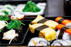 Set of variety sushi, Tamagoyaki, crabsticks sushi and maki in bento box served with soy sauce and wasabi. Delicious japanese food. photo