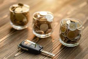 New car keys pile of coin on wooden table. Car financial, Car purchase, or car rental concept photo
