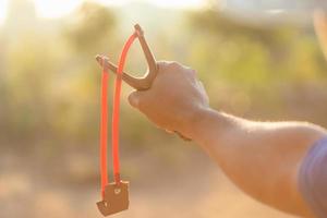 hombre jugando tirachinas o catapulta en la mañana con efecto de luz solar foto