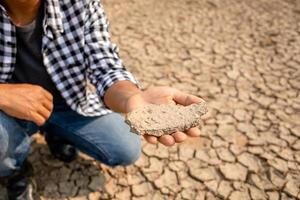 Farmer stand in the dry river and looking to empty water in Sukhothai. For drought season concept photo