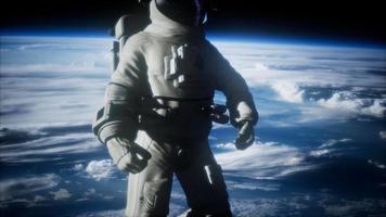 astronauta en el espacio ultraterrestre contra el telón de fondo del planeta tierra video