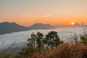 Sea Fog and Golden sunrise covers the area on the top of hill Doi Phu Thok, Chiang Khan, Loei, Thailand with background of sunrise on winter. photo