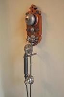 Vintage telephone hanging from a wall photo