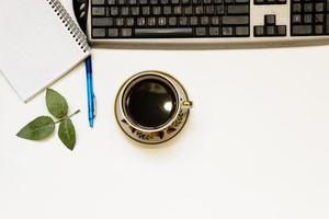 Cup of coffe and open notebook on white background photo