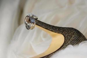 close up of wedding rings on bride's shoes photo