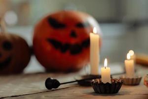 burning candles close up on a background of pumpkins. Halloween pumpkin head jack lantern with burning candles. illuminated halloween pumpkins with candles in the kitchen. photo