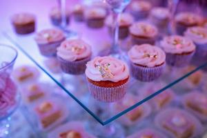 Set of different delicious tasty muffins on festive background. Different dessert tartlets with decorated cream. Selective focus. Candy bar concept photo