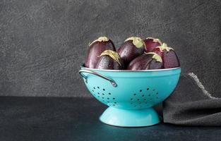 Fresh eggplants in the colander photo