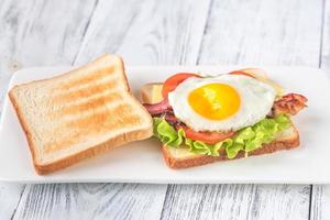 Sandwich with fried egg and bacon photo