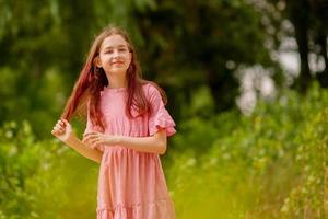 hermosa chica adolescente. niña de 10 años con un vestido rosa en un día soleado de verano. foto
