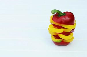 Sliced red chilli and yellow chilli stack on white wooden table photo