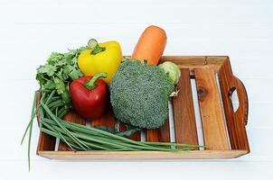 Mixed vegetable with Broccoli and chili and onion and carrot on wooden basket photo