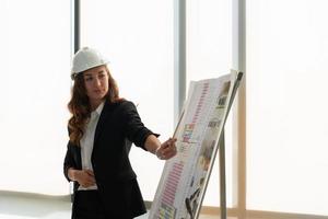 Portrait of Young Engineer Presenting Plan of Building photo