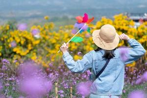 Portrait of Woman Walking in Pink and Yellow Flowers Field in Summer photo