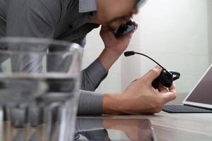 Man using VOIP headset with digital tablet computer docking smart keyboard, concept communication, it support, call center and customer service help desk,filter effect photo