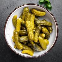 pepinillos pepinos salados verduras en escabeche en un tazón porción fresca foto