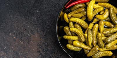 pepinillos pepinos salados verduras en escabeche en un tazón porción fresca foto