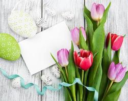 ramo de tulipanes y tarjeta de pascua de felicitación en blanco foto