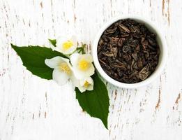 Dry green tea with jasmine flowers photo