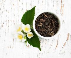 Dry green tea with jasmine flowers photo