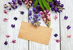 Lupine flowers with vintage card on a  table photo