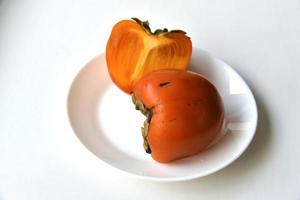Diospyros persimmon slices on a white plate photo