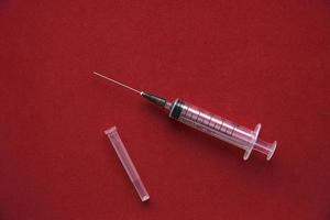 Medical syringe on a red background photo