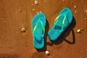 blue sandals on the beach , the concept of rest on the sea photo