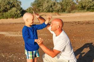 padre e hijo jugando junto al mar, familia feliz foto