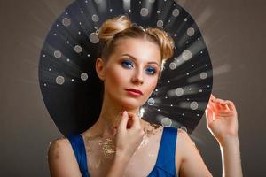 portrait of a beautiful woman with a make-up, original hat rays of light photo