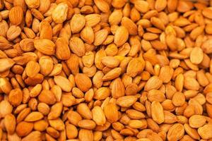 heap of peeled almond nuts close up as background photo