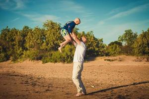 happy father and son walking on the beach photo