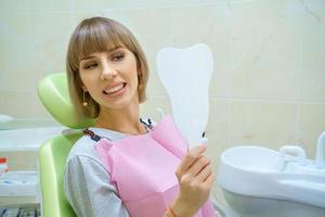 young happy woman sitting in the dentist's office, healthy teeth photo