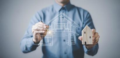 engineering and architecture drawings concept, Engineer man hold house on virtual screen of architect ,Insurance agent with model of house on light background,Property insurance and security concept. photo