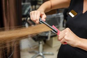 el peluquero corta el pelo del cliente foto